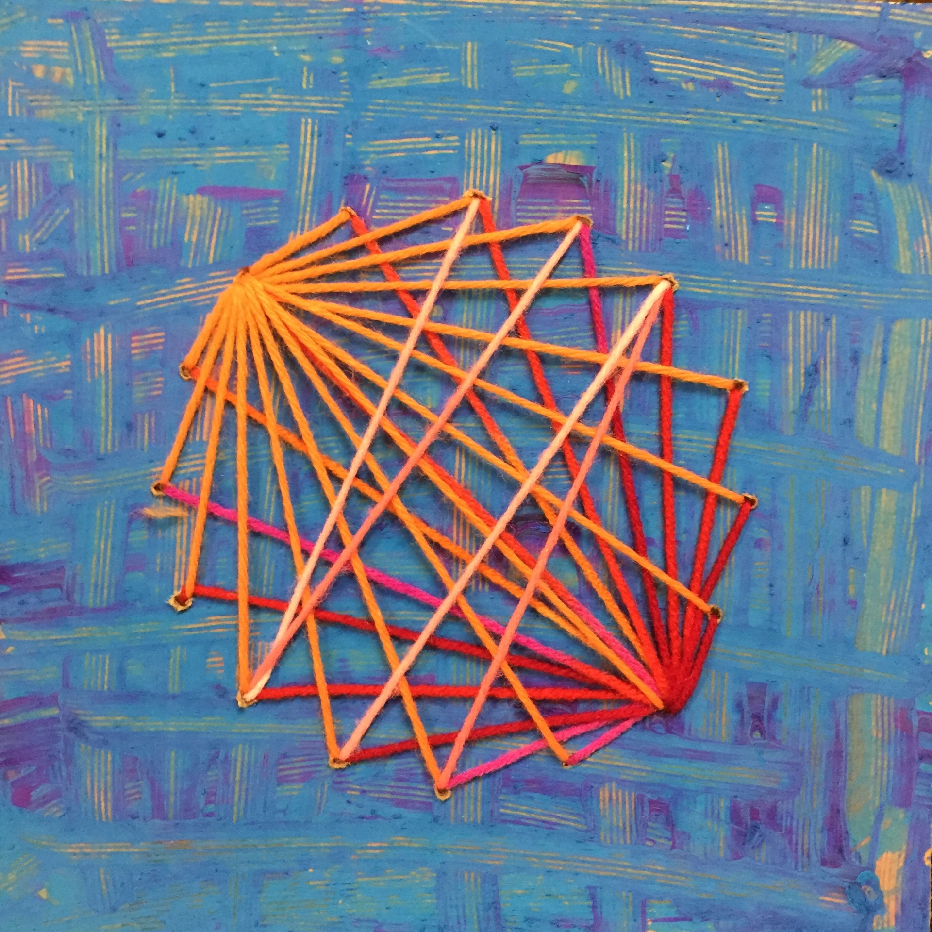 sample photo of Geometric String Art in orange and red yarn. 