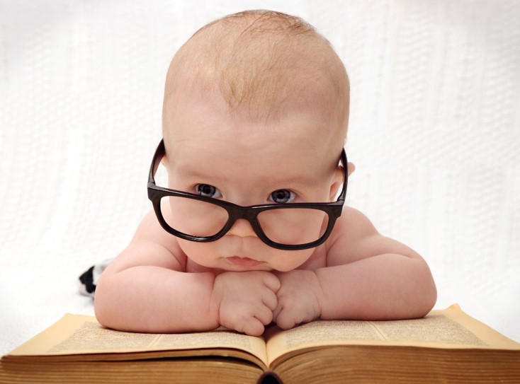 Baby with glasses on book