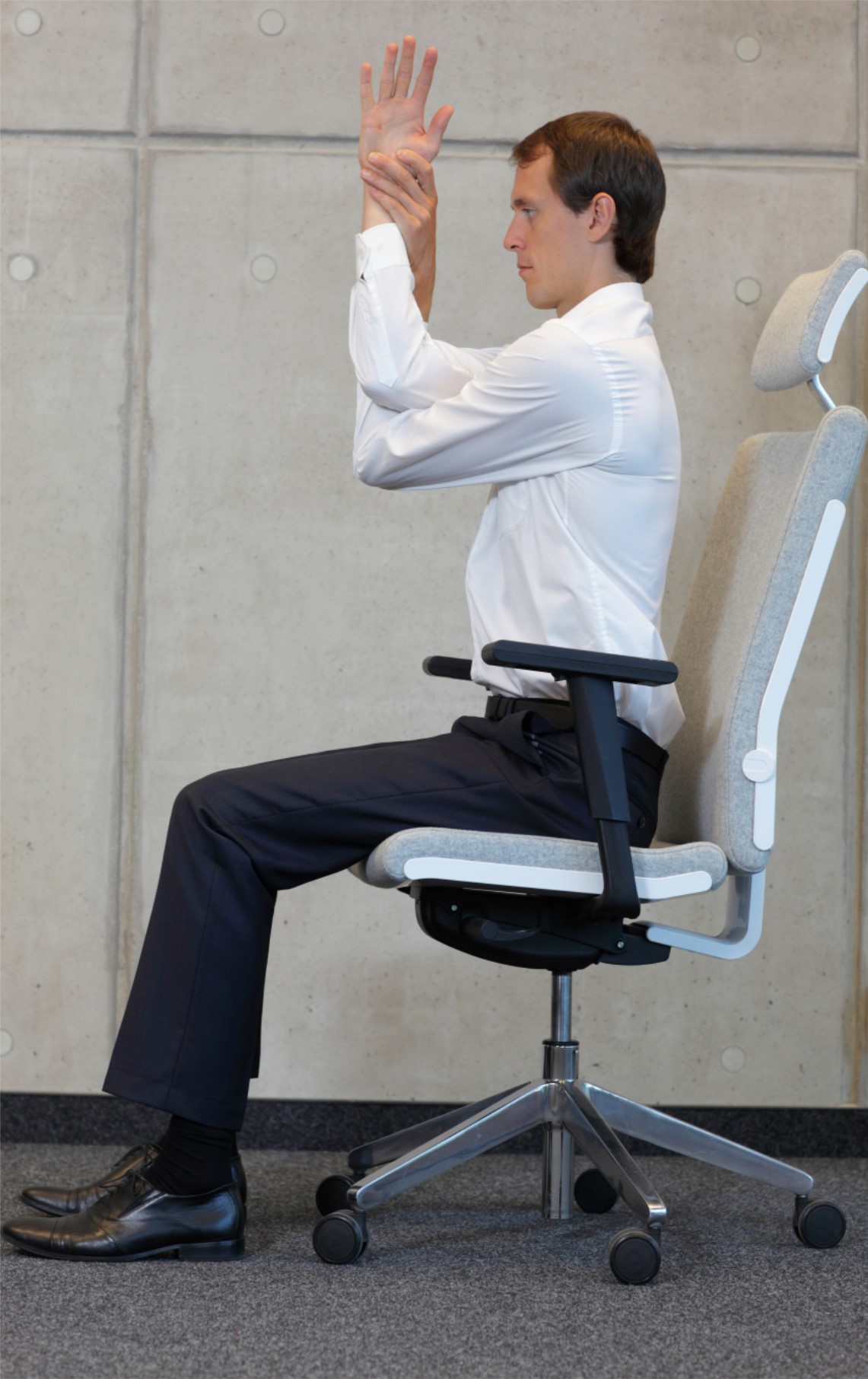 Man sitting in chair stretching arm.