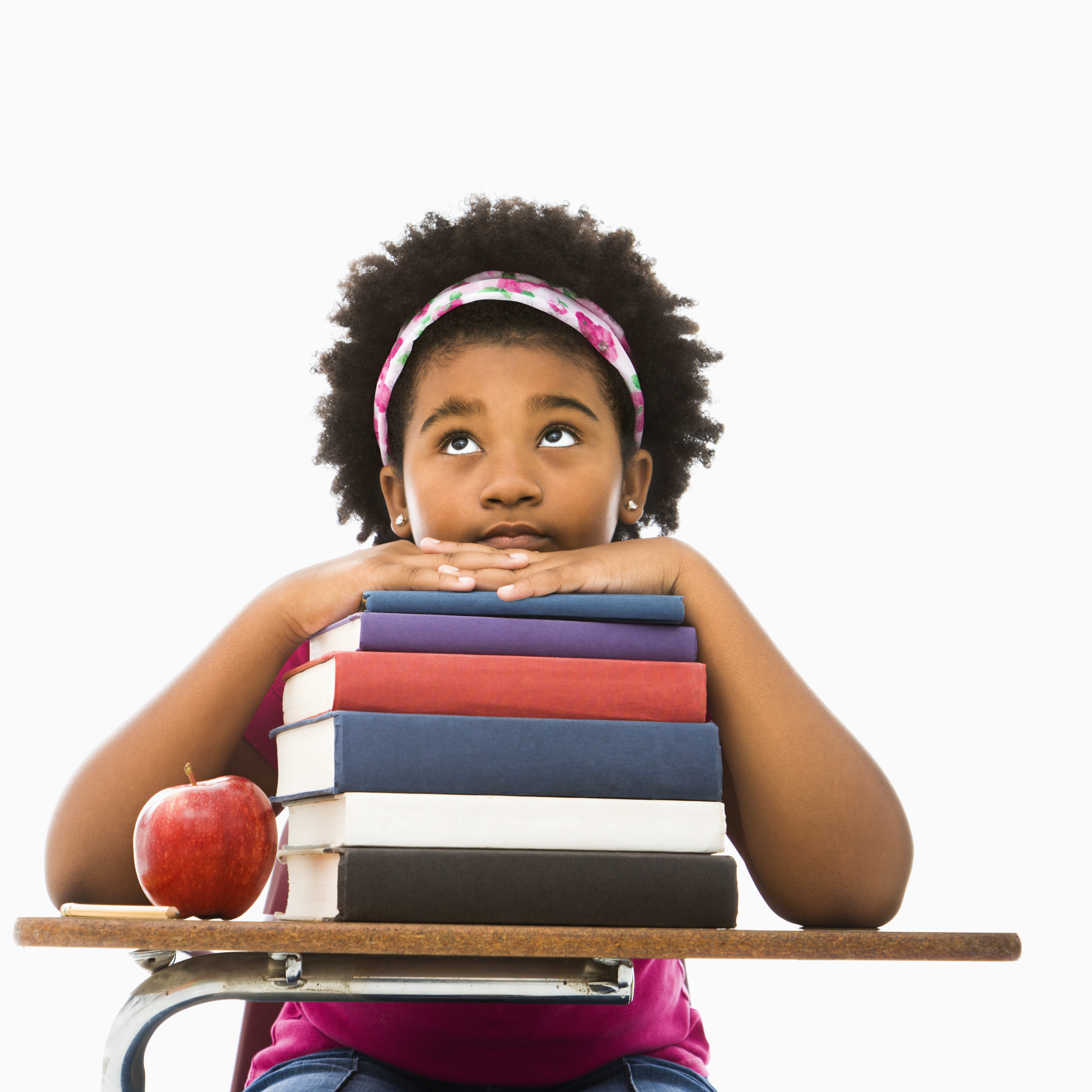 Girl sitting at desk with stack of books
