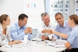 Group of people in blue shirts meeting around a circular table