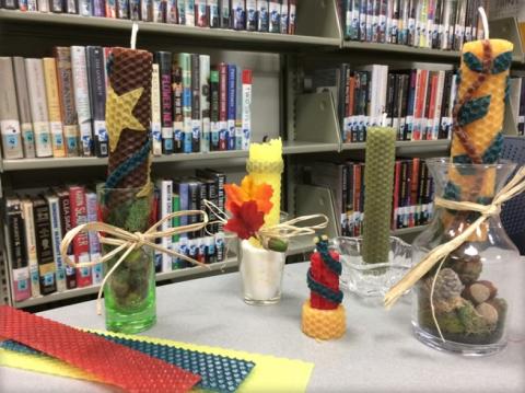 Several beeswax candles of various designs on a table