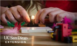 Adolescent making a small light-bulb light up with circuits. 