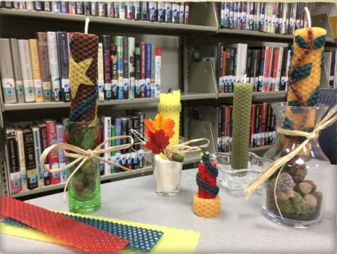 Multi-colored beeswax candles sitting on a table. 