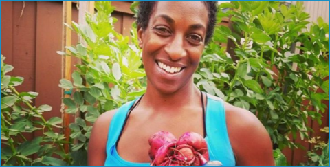 African-American woman holding fruit.