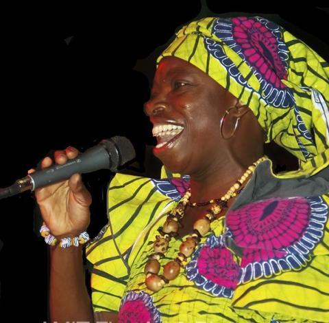 Picture of African woman in a traditional bright yellow & purple dress from Ghana