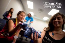 Two girls in a classroom playing with messy blue slime