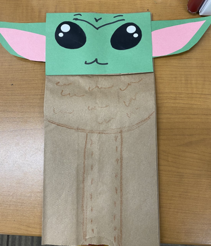 Image of a baby Yoda from the show, "The Mandalorian" made of a paper bag and construction paper.