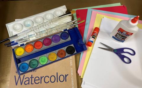 Art supplies: watercolor paints, colored papers, glue, scissors