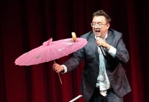 A man spinning a parasol with a hamburger on it.