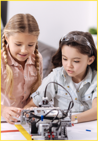 Two tween girls working on a robotics project