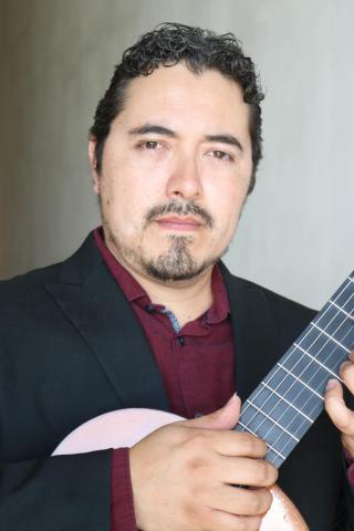 Portrait of musician Jose Rodriguez holding a guitar