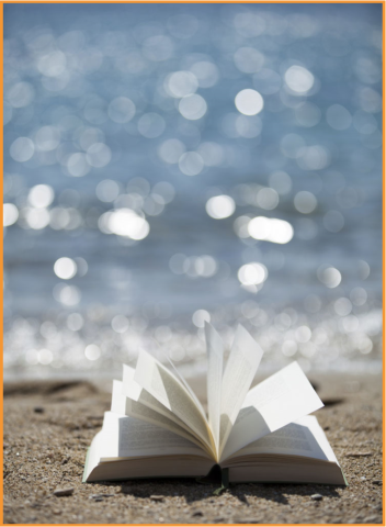 Open book on the beach with sun shimmering on the water