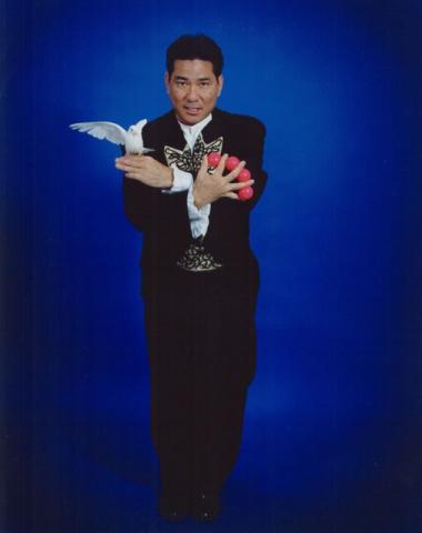 Magician holding a dove in one hand and small balls in the other