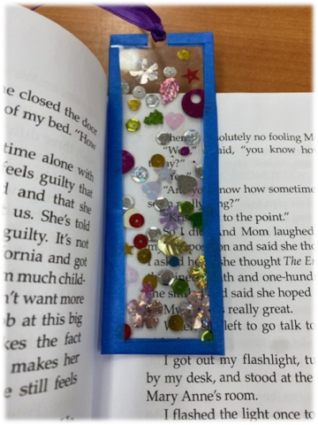 Clear bookmark with sequins inside a book