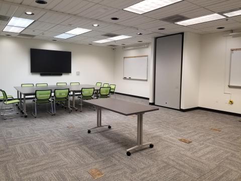 Room with TV Monitor, tables, chairs, whiteboards