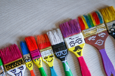 paint brushes with faces painted on them