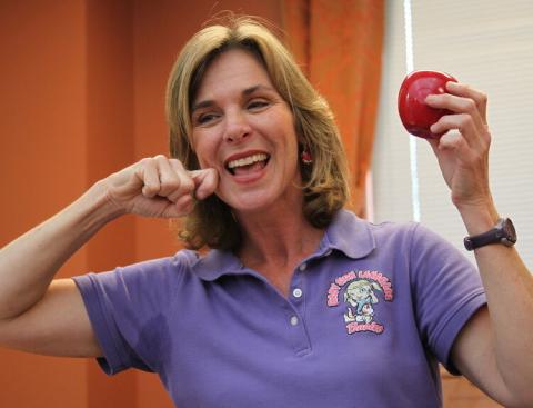 Woman wearing purple polo signing Apple in ASL