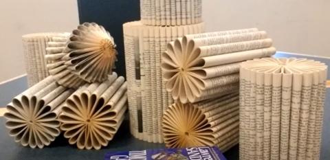 Books with pages folded to create floral art.  