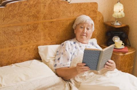 Elderly woman reading in bed