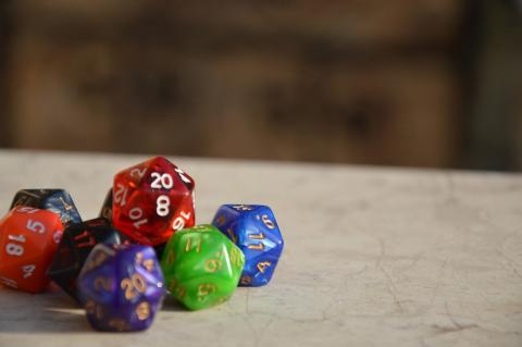 A stack of different colored twenty-sided dice on a leather mat.