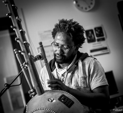 black and white photo of a man with a percussive musical instrument.