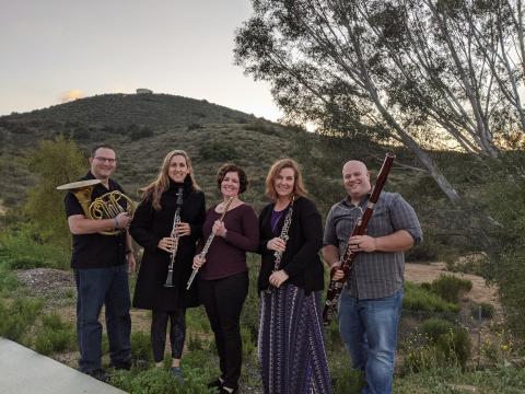 5 members of the Left Coast Quintet standing outside with their musical instruments.  