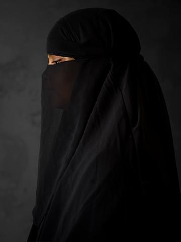 Photographic portrait of a woman in a black religious veil by artist John Raymond Mireles.