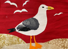 Quilt square of a seagull on sand dunes by a local community member.