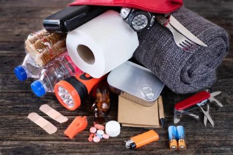 essential items you would find in a go bag like toilet paper, batteries, knife, water, radio