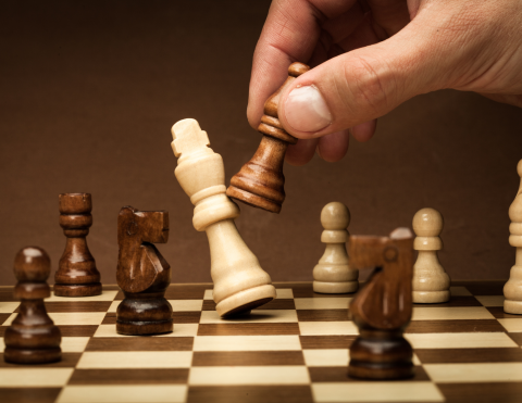 Image of fingers interacting with chess pieces