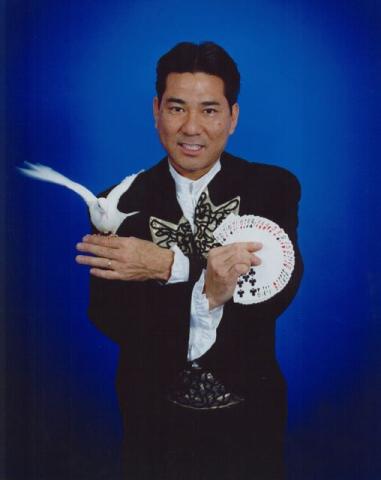 Magician with a fan of playing cards and white dove