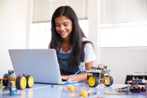 girl sitting with laptop and robotics parts