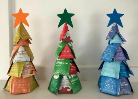 Three small Christmas trees decorated with colorful tea bags