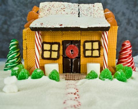 Holiday cookie house made with wafer cookies, chocolate bark, gummy candy and candy cane