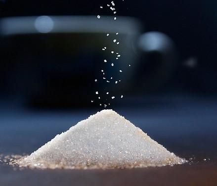 small pile of sugar with cup in background