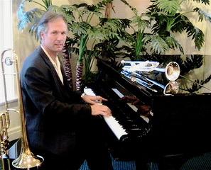 Photo of Dean Ratzman sitting at a grand piano