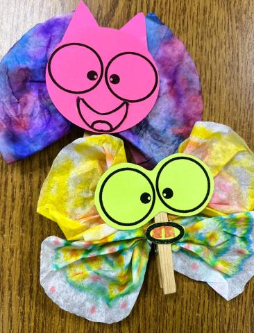 Coffee filters colored with watercolors, clipped with clothes hangers to make a body, and paper faces glued on.