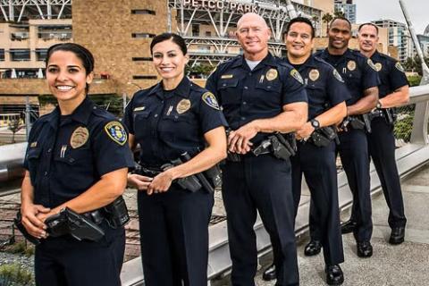 Six San Diego Police Officers standing and smiling in front of Petco Park.