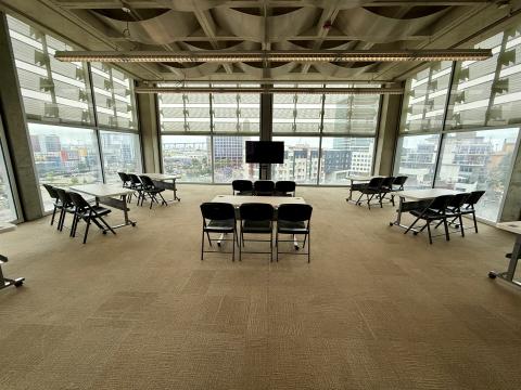 Meeting room with tables, chairs, and a TV