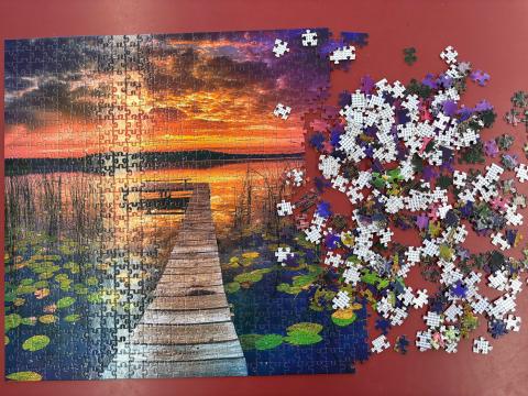 Mostly-completed jigsaw puzzle, next to loose pieces.