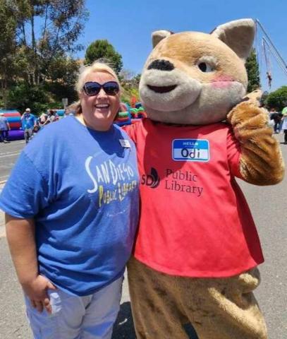 library employee poses with library mascot
