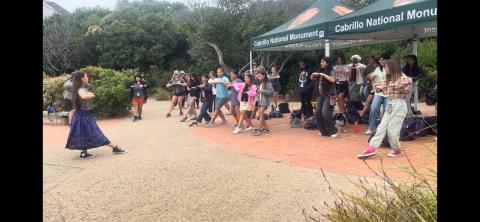 a crowd participating in a dance activity led by an instructor