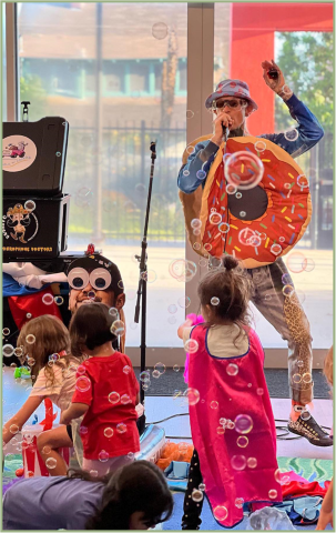 Male singer wearing pink donut costume.