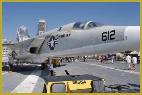 Image of a fighter jet on top of an aircraft carrier.
