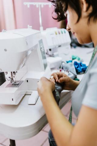 Person using sewing machine to sew. 