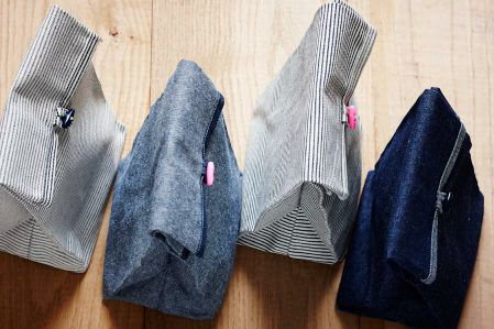 A photo of four denim lunch bags.