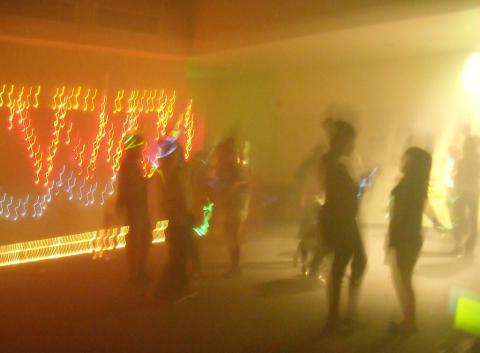 teens hanging out in a room with LEDs on the wall