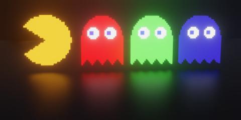 Yellow Pac-man on left side with a red, green, and blue videogame ghost lined up after the Pac-man