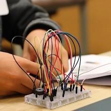Person working on breadboard with lots of colorful wires inserted into it